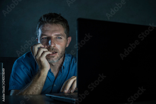 young aroused and excited sex addict man watching porn mobile online in laptop computer light night at home in pornography addiction internet pornographic content