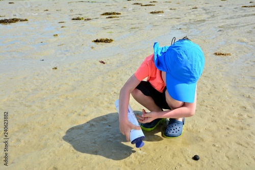 Un petit garçon qui pêche des couteaux à marée basse en Bretagne