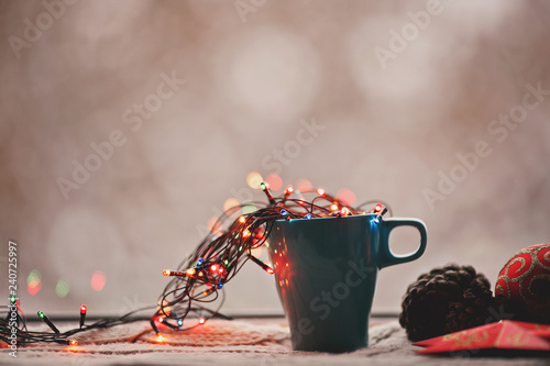 Beautiful cup at the window with Christmas lights and decorations