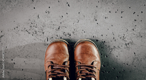 A pair of children's leather shoes on a dark, stone background. Top view for warm, mid-winter boots, fashion concept and dress code for children. Blank background is content supplement.