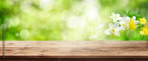 Green spring background with wooden table