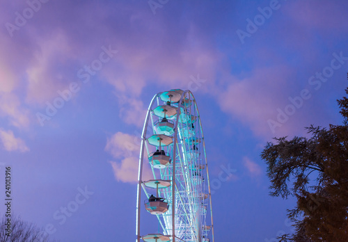 The big ferris wheel on background of sunny blue sky