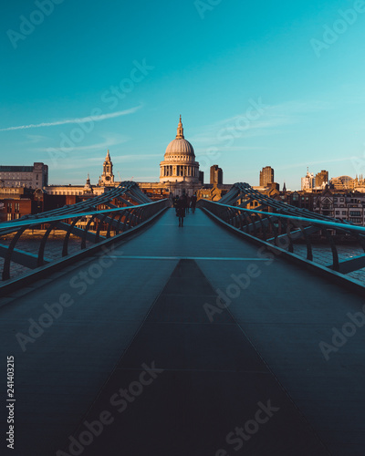 Millennium Bridge St Paul's Cathedral on modern London city skyline blue sky