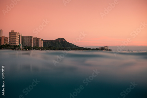 A pink sky forms as the sunsets off of Diamond Head on Oahu Hawaii