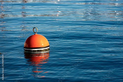 Red and orange mooring buoy in the sea