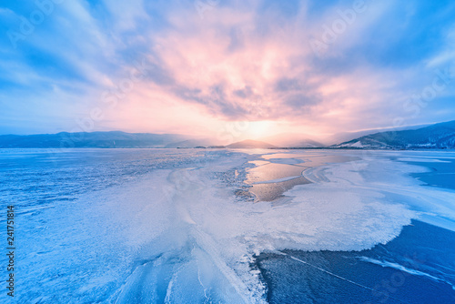 Frozen surface of Baikal lake at sunset.
