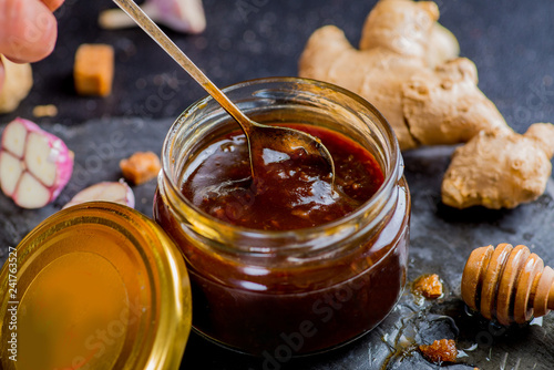 teriyaki sauce in a jar and ingredients from it on a black background