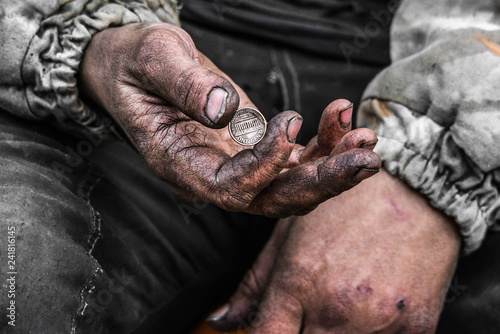 Homeless poor man with one cent coin in the street