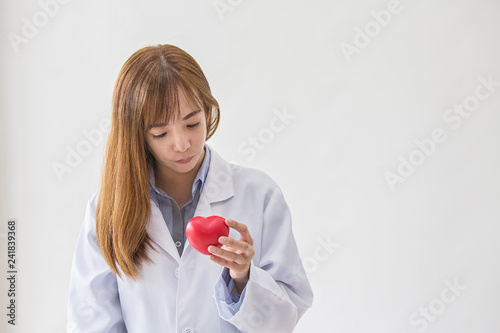 Portrait of smiling female doctor with red heart. Friendly young woman doctor with red heart on hand. asia.