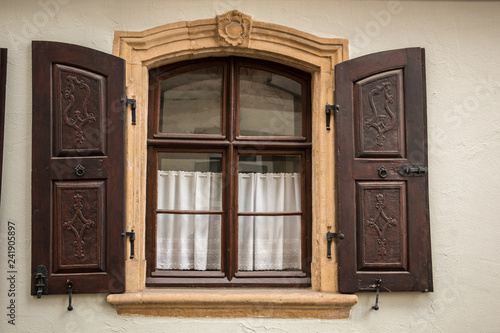 Old window made of stone and wood with brown shutters