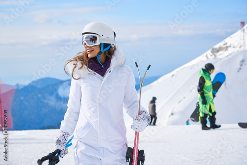 woman skier close up portrait wearing white healmet with mask in snow winter mountain