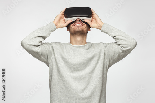 Caucasian male wearing virtual reality goggles and enjoying games