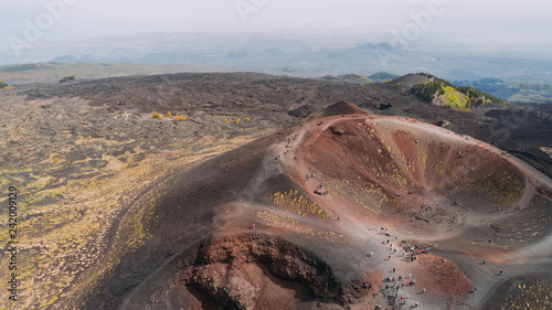 Aerial panorama of collapsed volcano cone, Mount Etna, Sicily, Italy.Etna crater, scenic volcanic landscape,popular tourist attraction,hikers destination.People walking on edge of crater