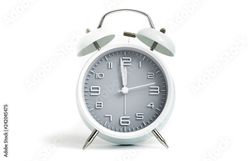 Table alarm clock shows time 1 minute to 12 o'clock with gray clock face, 11.59 AM PM, on white background