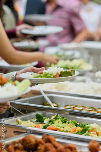scooping the food, buffet food at restaurant, catering 