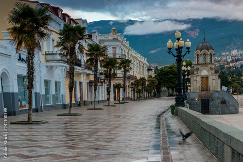 Embankment of the Russian city of Yalta in the autumn afternoon, view of the city and mountains