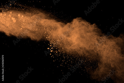 abstract brown powder splatted background. Colorful powder explosion on black background. Colored cloud. Colorful dust explode. Paint Holi.