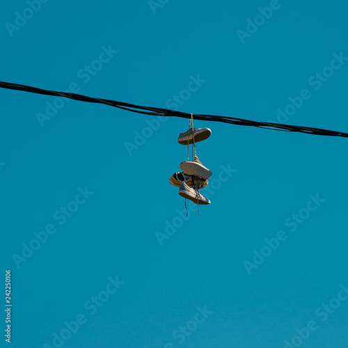 Sneakers hanging on a sky background. The concept of urban kultruta, sale of prohibited substances, ghetto