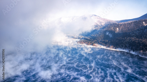 aerial view of the mountains and the blue river in the fog