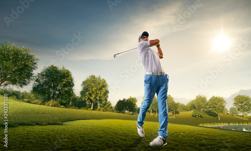 Male golf player on professional golf course. Golfer with golf club taking a shot