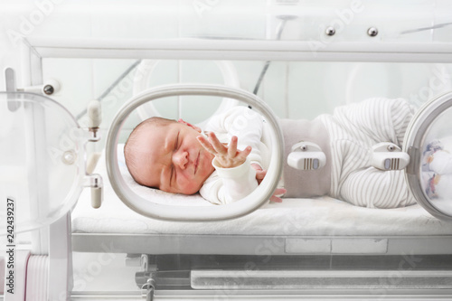 Nowonarodzone dziecko w inkubatorze na oddziale szpitalnym.