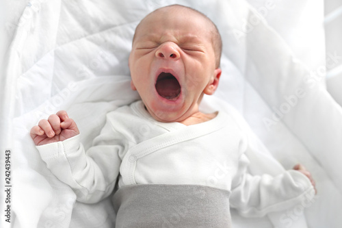 Płaczący noworodek. Pierwsze dni na świecie, noworodek śpi w łóżeczku.