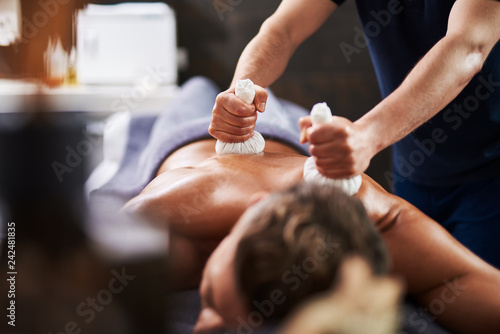 Young man having Ayurveda procedure at wellness center