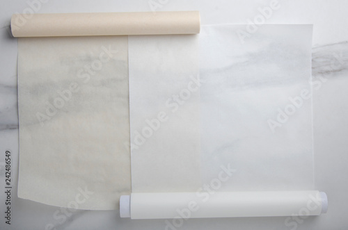 Two types of paper for baking on marble table