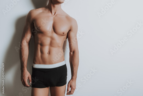 Young shirtless athletic man standing in black underwear