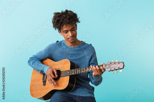 Handsome young african man playing a guitar