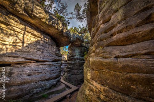 Passage with wooden walkway in stone labyrinth Bledne skaly in National Park Stolowe Mountains, Poland