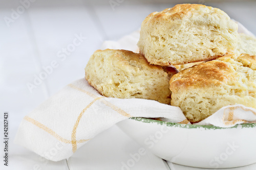 Fresh buttermilk southern biscuits or scones from scratch in a white bowl.