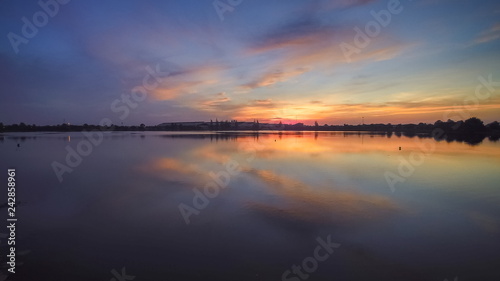 Top view evening above the lake, beautiful vivid red sky and reflection on the surface of water, sunset at Krajub reservoir, Banpong District, Ratchaburi, western of Thailand.