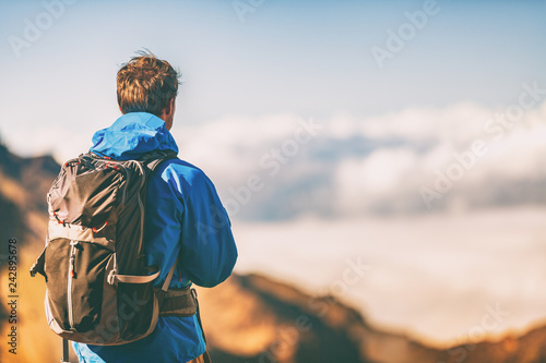 Hiker travel lifestyle young man wearing jacket and backpack on trek trip outdoor in mountains.