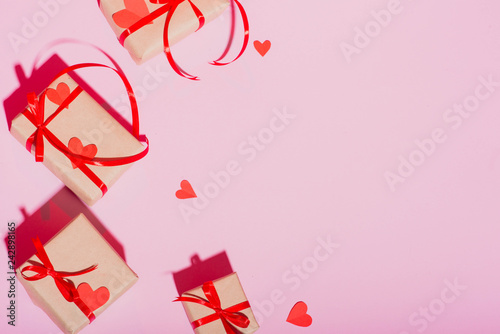 Valentine's Day gift on a pink background lie with a red ribbon hearts with love frame place for text isolate