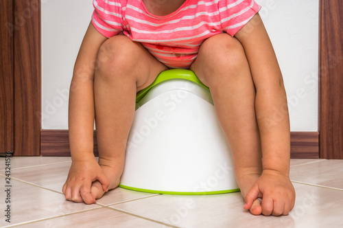 Child is sitting on baby potty