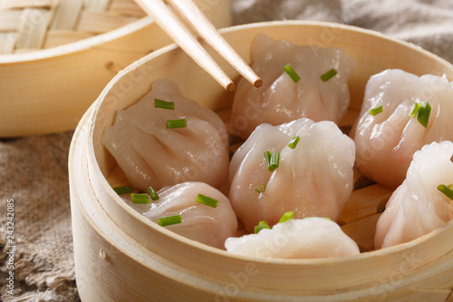 Chinese prawn dumplings dim sum placed in a bamboo steamer on the table. horizontal