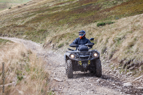 Front view of quad bike zipping along a country road.