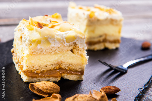 Homemade cake with whipped cream, almonds petals, toffi cream