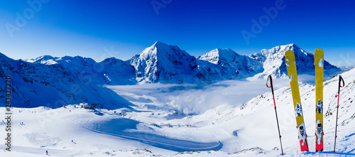 Ski in winter season, mountains and ski touring backcountry equipments on the top of snowy mountains in sunny day. South Tirol, Solda in Italy.