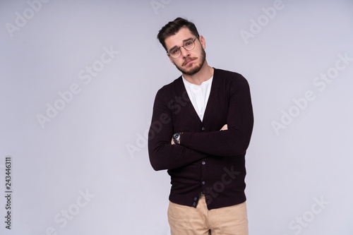 Portrait of sad upset young guy looking at camera over white background