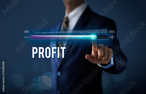 Profit growth, increase profit, raise profit or business growth concept. Businessman is pulling up progress bar with the word PROFIT on dark tone background.