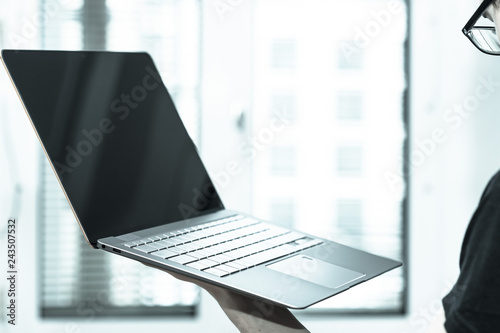 Young freelancer is holding up a thin elegant notebook