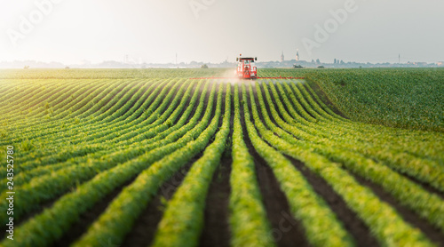 Tractor spraying pesticides at soy bean field