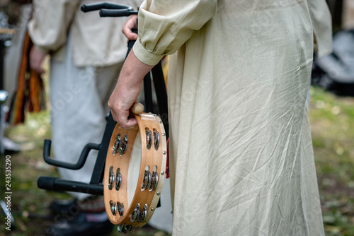 A woman in national costume holds a tambourine in her hands.