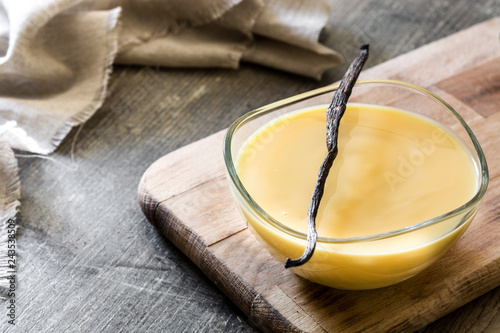 Bowl of homemade vanilla custard on wooden table