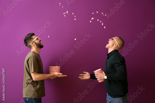 Guys catching popcorn with their mouths on color background