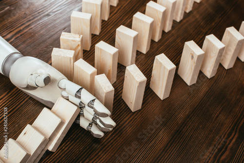 robotic hand preventing wooden blocks from falling on desk