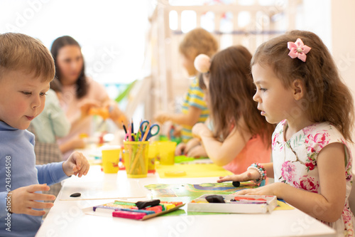 Kindergarten kids three years old on developing class play with plasticine