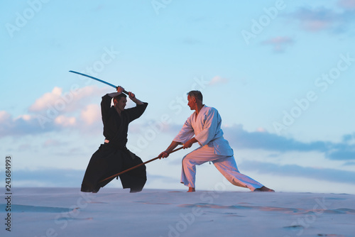 Concentrated men, in Japanese clothes, are practicing martial arts